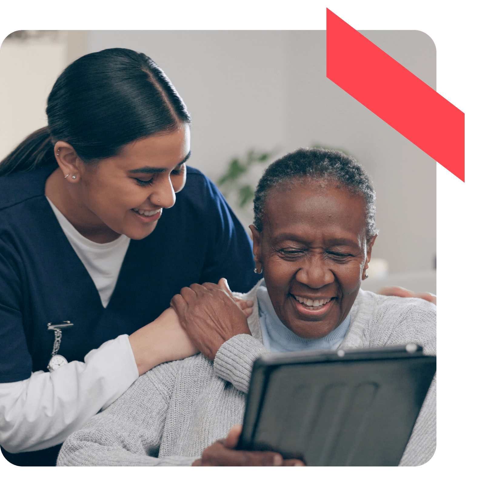 A hospital healthcare provider helps an elderly patient review important information on a tablet