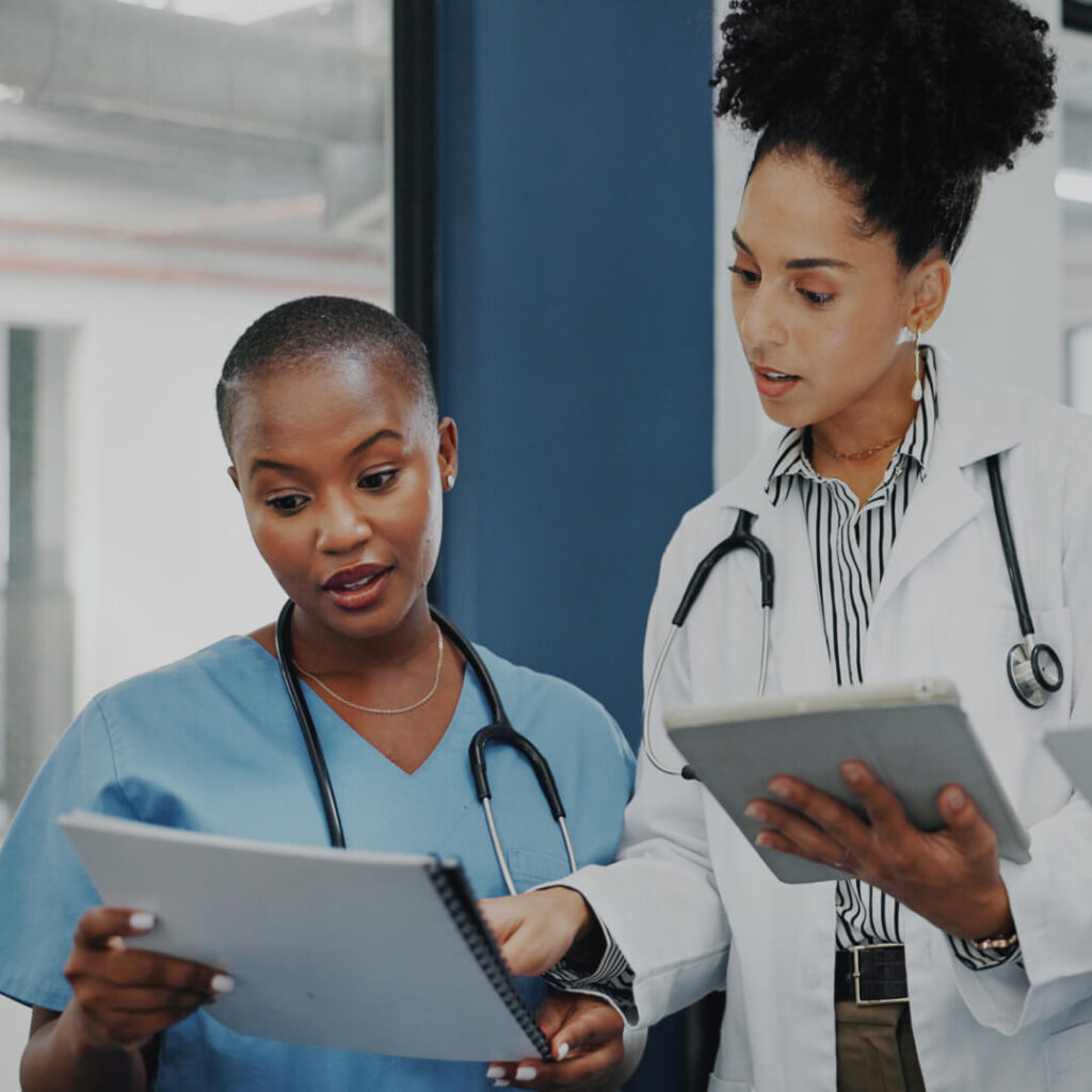 A nurse in scrubs and a physician review paperwork in a facility representing Saint Luke’s Health System